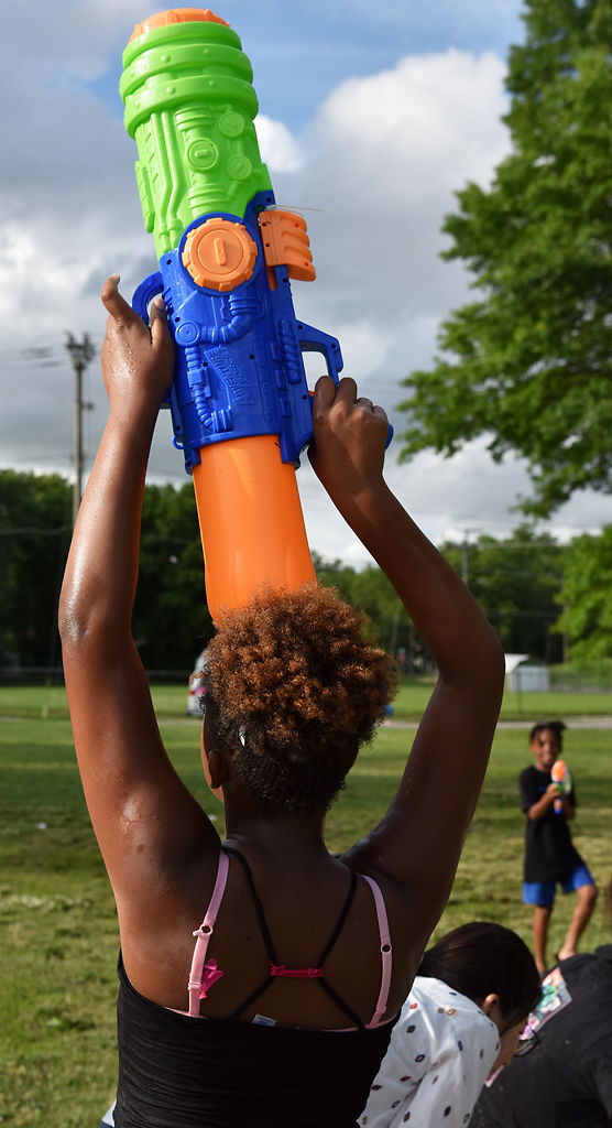 Ma'Layzia Stapleton Edwards holds her gun above her head to get the water pumping